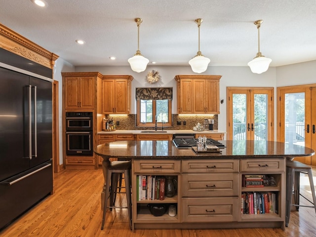 11576 NW Timberbrooke Ln, Grimes, IA 50111 - kitchen featuring built in refrigerator, open shelves, backsplash, light wood-type flooring, and hanging light fixtures