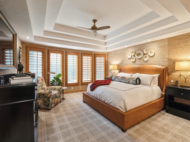 11576 NW Timberbrooke Ln, Grimes, IA 50111 - bedroom featuring a raised ceiling, multiple windows, and a ceiling fan