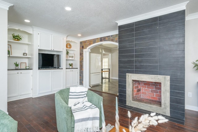 4005 Beaver Ave, Des Moines, IA 50310 - living room featuring crown molding, arched walkways, a textured ceiling, dark wood finished floors, and baseboards