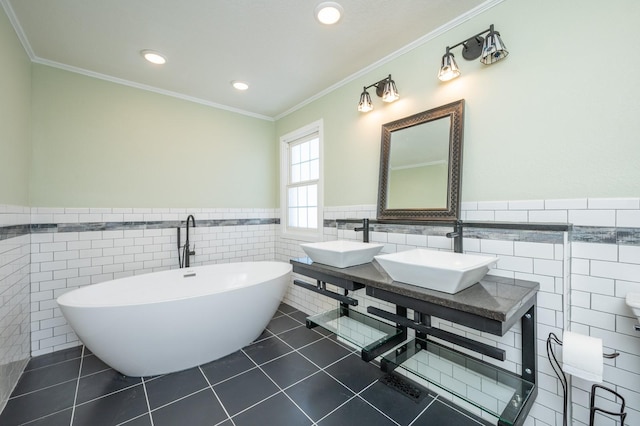 4005 Beaver Ave, Des Moines, IA 50310 - bathroom with tile walls, tile patterned flooring, a soaking tub, double vanity, and wainscoting
