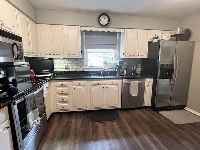 313 E 29th St S, Newton, IA 50208 - kitchen with appliances with stainless steel finishes, a sink, dark wood finished floors, and dark countertops