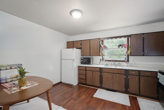 4413 SE 7th St, Des Moines, IA 50315 - kitchen featuring freestanding refrigerator, black microwave, a sink, and light countertops