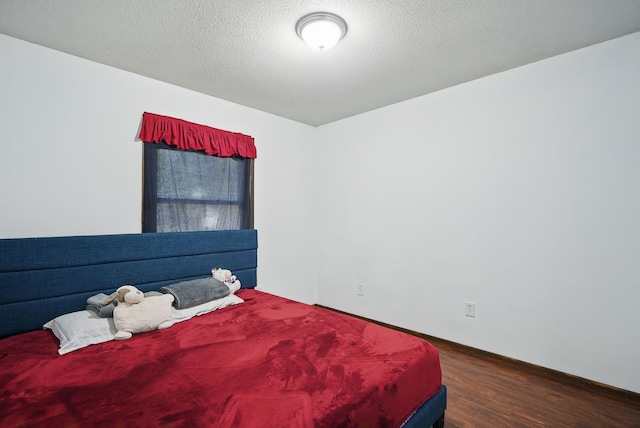 4413 SE 7th St, Des Moines, IA 50315 - bedroom with wood finished floors, a textured ceiling, and baseboards