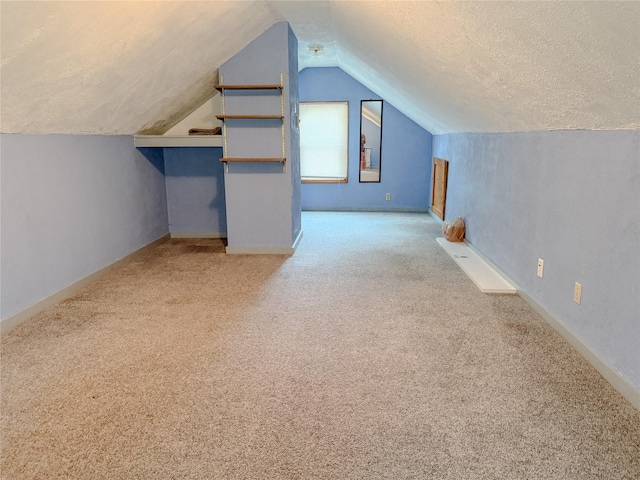 6465 NW 56th St, Johnston, IA 50131 - additional living space with vaulted ceiling, a textured ceiling, carpet flooring, and baseboards