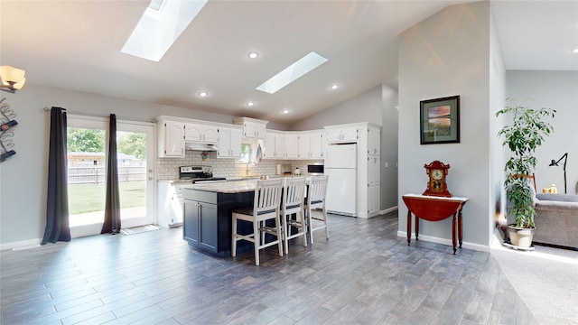 416 S Park St, Stuart, IA 50250 - kitchen featuring freestanding refrigerator, electric range, a skylight, white cabinetry, and lofted ceiling
