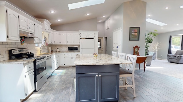 416 S Park St, Stuart, IA 50250 - kitchen with a skylight, appliances with stainless steel finishes, lofted ceiling, a sink, and under cabinet range hood