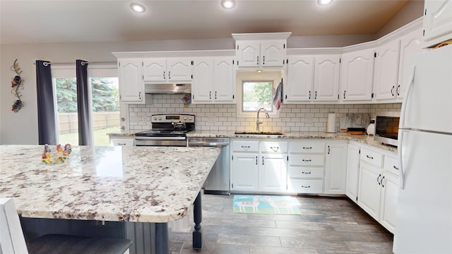 416 S Park St, Stuart, IA 50250 - kitchen with appliances with stainless steel finishes, extractor fan, a sink, white cabinetry, and dark wood-style flooring