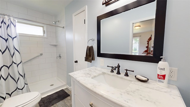 416 S Park St, Stuart, IA 50250 - bathroom with vanity, a tile shower, plenty of natural light, and toilet