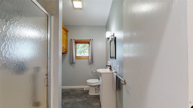 416 S Park St, Stuart, IA 50250 - bathroom featuring vanity, a shower stall, toilet, wood finished floors, and baseboards