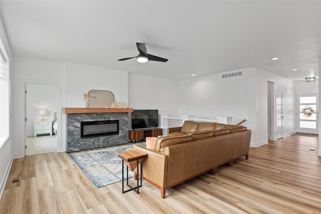 110 Bailey Cir, Waukee, IA 50263 - living area featuring light wood-style floors, a high end fireplace, ceiling fan, recessed lighting, and baseboards