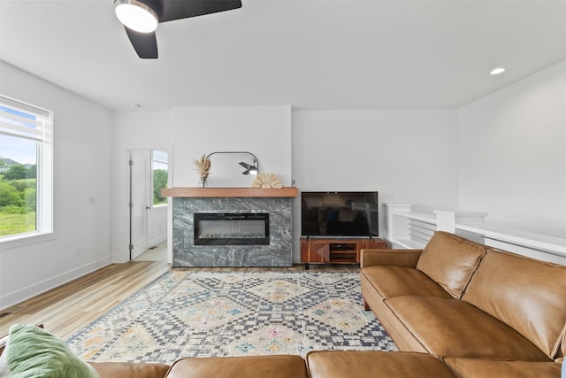 110 Bailey Cir, Waukee, IA 50263 - living room with wood finished floors, ceiling fan, a fireplace, and baseboards