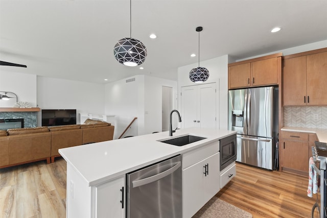 110 Bailey Cir, Waukee, IA 50263 - kitchen with stainless steel appliances, a sink, backsplash, light wood-type flooring, and recessed lighting