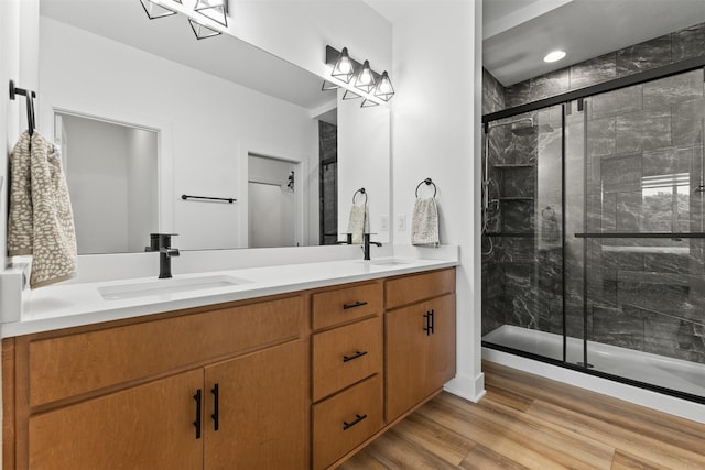 110 Bailey Cir, Waukee, IA 50263 - full bathroom with double vanity, a shower stall, and wood finished floors