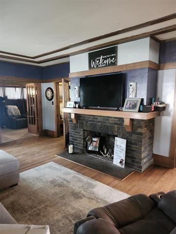230 Grant St, Murray, IA 50174 - living area with a fireplace, wood finished floors, and crown molding