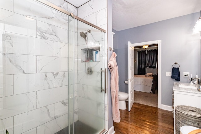 2212 228th Pl, Ames, IA 50014 - bathroom featuring a shower stall, vanity, wood finished floors, toilet, and baseboards