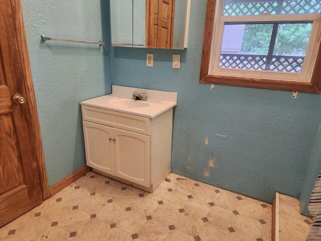 1512 Osceola Ave, Chariton, IA 50049 - bathroom with tile patterned floors, vanity, and a textured wall