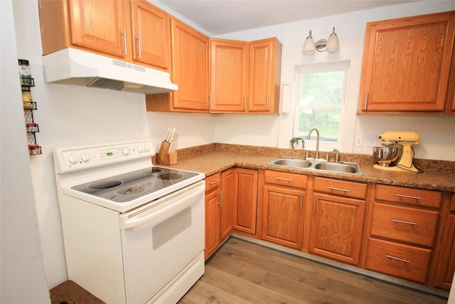 1035 65th St, Windsor Heights, IA 50324 - kitchen featuring white range with electric stovetop, under cabinet range hood, a sink, light wood finished floors, and brown cabinetry