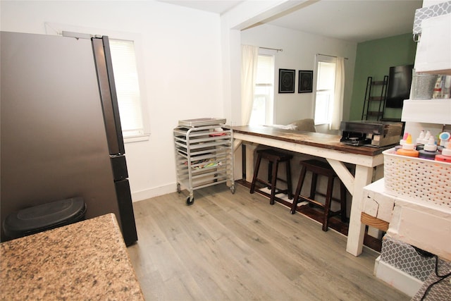 1035 65th St, Windsor Heights, IA 50324 - kitchen featuring freestanding refrigerator, light wood finished floors, and baseboards