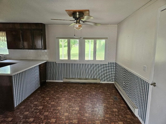 205 Amy Ln, Mount Ayr, IA 50854 - kitchen featuring a baseboard heating unit, brick patterned flooring, a ceiling fan, light countertops, and wallpapered walls