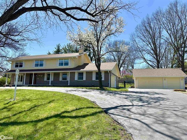3316 Southern Hills Dr, Des Moines, IA 50321 - view of front facade with a chimney, a garage, a front yard, and covered porch