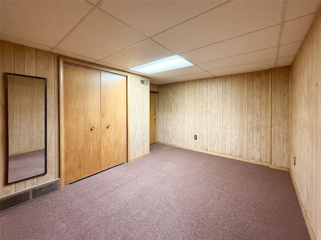 1545 5th St, Boone, IA 50036 - unfurnished bedroom featuring a paneled ceiling, carpet floors, a closet, and wood walls