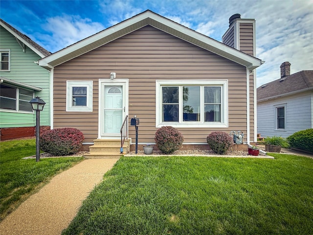 1545 5th St, Boone, IA 50036 - view of front facade with entry steps, a chimney, and a front yard