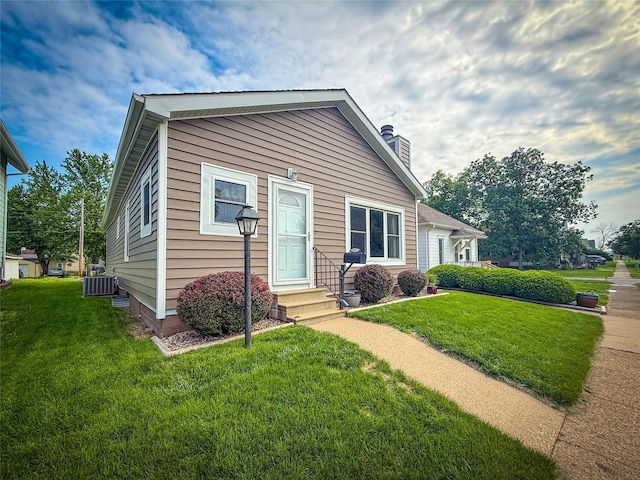 1545 5th St, Boone, IA 50036 - bungalow with a chimney, a front lawn, central air condition unit, a garage, and entry steps