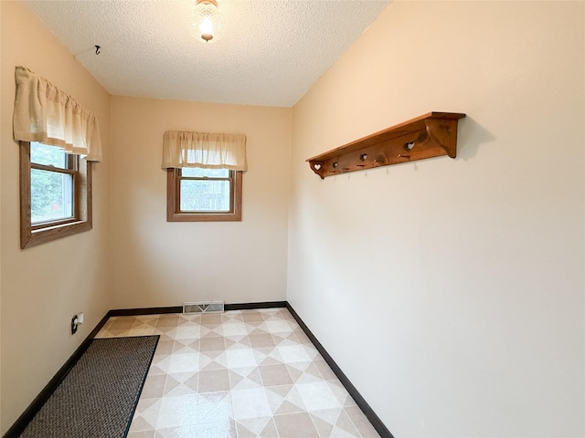 1545 5th St, Boone, IA 50036 - unfurnished room featuring plenty of natural light, a textured ceiling, and baseboards