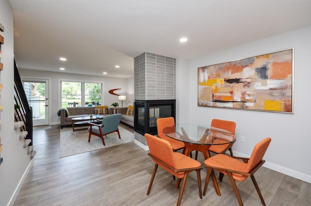 6196 Terrace Dr Unit 2, Johnston, IA 50131 - dining area featuring a fireplace, wood finished floors, recessed lighting, baseboards, and stairway