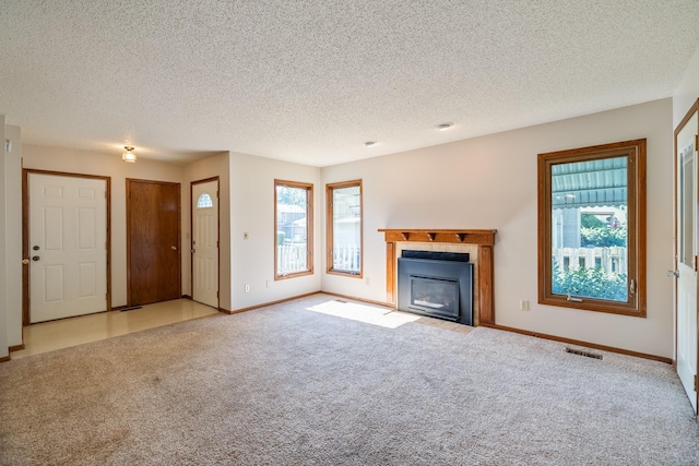 3916 92nd Dr, Urbandale, IA 50322 - unfurnished living room with healthy amount of natural light, a fireplace with flush hearth, carpet floors, and a textured ceiling