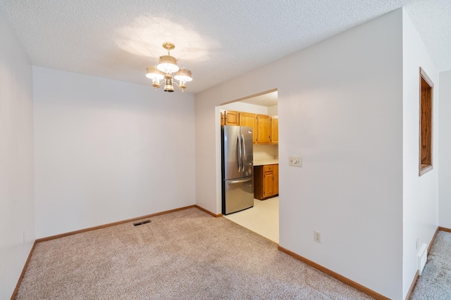 3916 92nd Dr, Urbandale, IA 50322 - unfurnished room with light carpet, a chandelier, and a textured ceiling