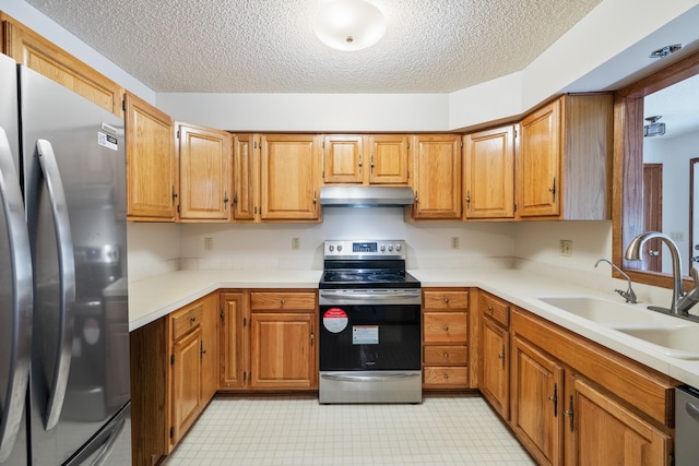 3916 92nd Dr, Urbandale, IA 50322 - kitchen with appliances with stainless steel finishes, under cabinet range hood, a textured ceiling, light countertops, and brown cabinetry