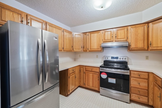 3916 92nd Dr, Urbandale, IA 50322 - kitchen featuring appliances with stainless steel finishes, under cabinet range hood, a textured ceiling, light countertops, and light tile patterned floors