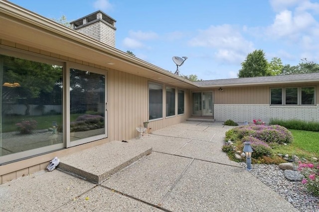 2110 Ashmore Dr, Ames, IA 50014 - back of house with a patio, brick siding, and a chimney