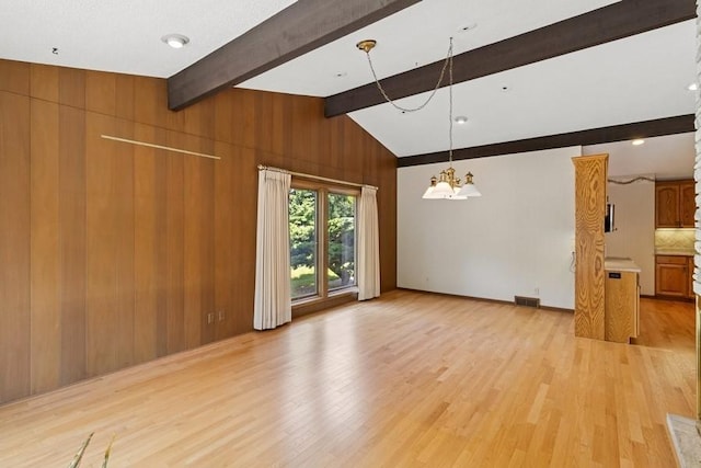 2110 Ashmore Dr, Ames, IA 50014 - unfurnished living room featuring a chandelier, light wood-style floors, and wooden walls