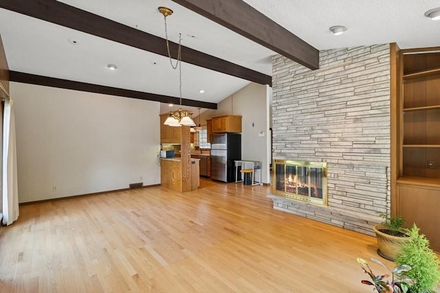 2110 Ashmore Dr, Ames, IA 50014 - unfurnished living room with a stone fireplace, light wood-style floors, baseboards, and a chandelier