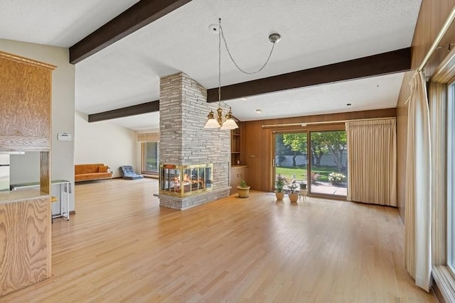 2110 Ashmore Dr, Ames, IA 50014 - unfurnished living room featuring beamed ceiling, light wood-style floors, and a multi sided fireplace