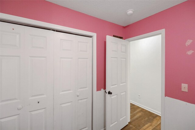 1908 E Walnut St, Des Moines, IA 50316 - unfurnished bedroom featuring dark wood-type flooring, a closet, and baseboards
