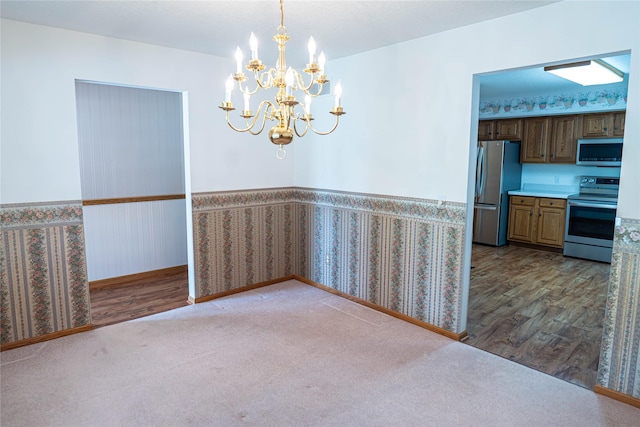 1126 SE Mallard Creek Dr, Ankeny, IA 50021 - unfurnished dining area featuring wainscoting, a chandelier, wood finished floors, wallpapered walls, and carpet flooring