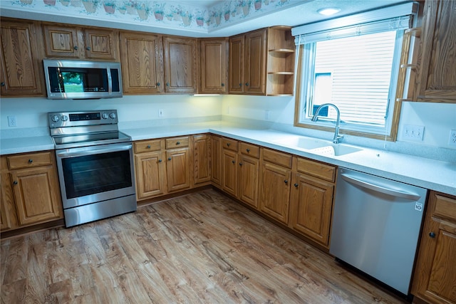 1126 SE Mallard Creek Dr, Ankeny, IA 50021 - kitchen featuring stainless steel appliances, a sink, light countertops, light wood finished floors, and brown cabinetry