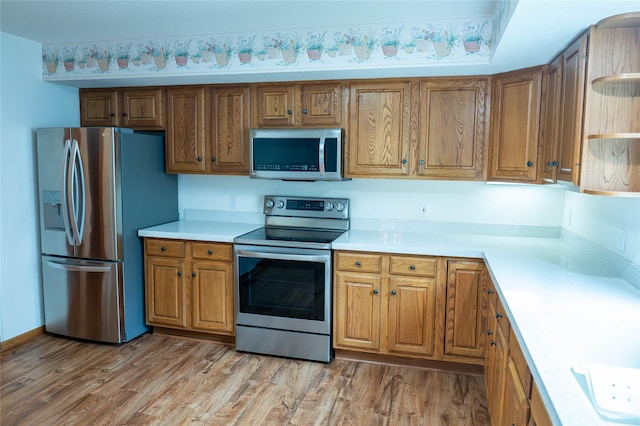 1126 SE Mallard Creek Dr, Ankeny, IA 50021 - kitchen featuring appliances with stainless steel finishes, open shelves, light countertops, and light wood finished floors