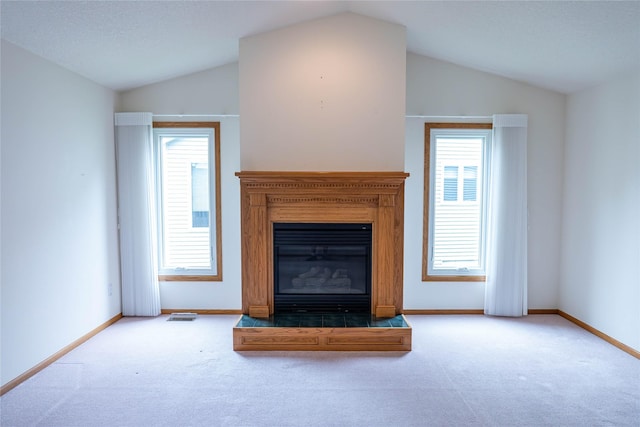 1126 SE Mallard Creek Dr, Ankeny, IA 50021 - unfurnished living room featuring lofted ceiling, carpet flooring, baseboards, and a glass covered fireplace