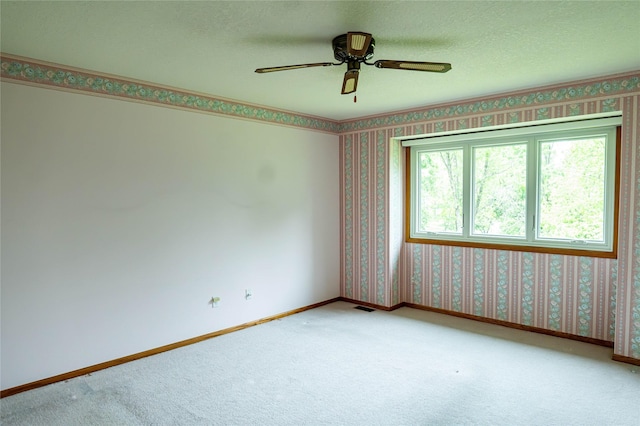 1126 SE Mallard Creek Dr, Ankeny, IA 50021 - carpeted empty room with wallpapered walls, baseboards, a ceiling fan, and a textured ceiling