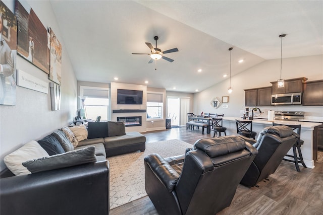 602 NE 57th St, Ankeny, IA 50021 - living room featuring dark wood-style floors, vaulted ceiling, a ceiling fan, a fireplace, and recessed lighting