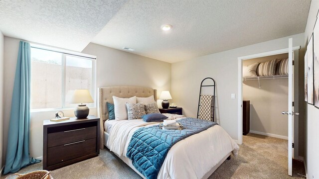 480 Kinley Dr, Waukee, IA 50263 - bedroom with light colored carpet, a textured ceiling, a walk in closet, and a closet