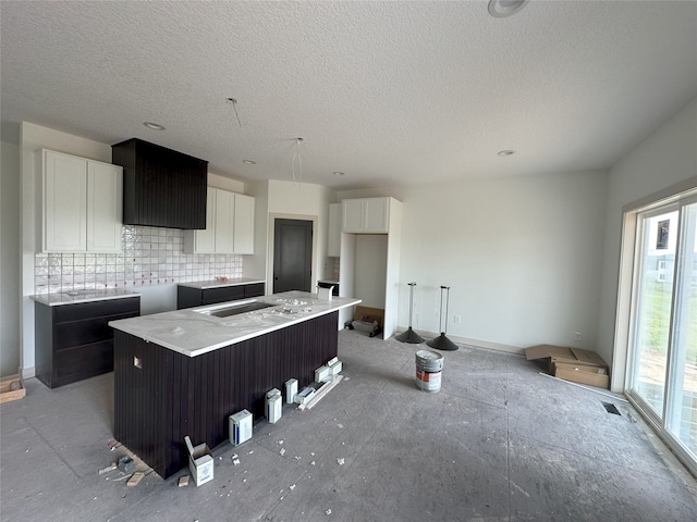4192 NW 177th St, Clive, IA 50325 - kitchen with backsplash, white cabinetry, a textured ceiling, and a center island