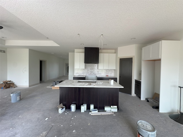 4192 NW 177th St, Clive, IA 50325 - kitchen featuring a center island, a textured ceiling, white cabinetry, decorative backsplash, and light countertops