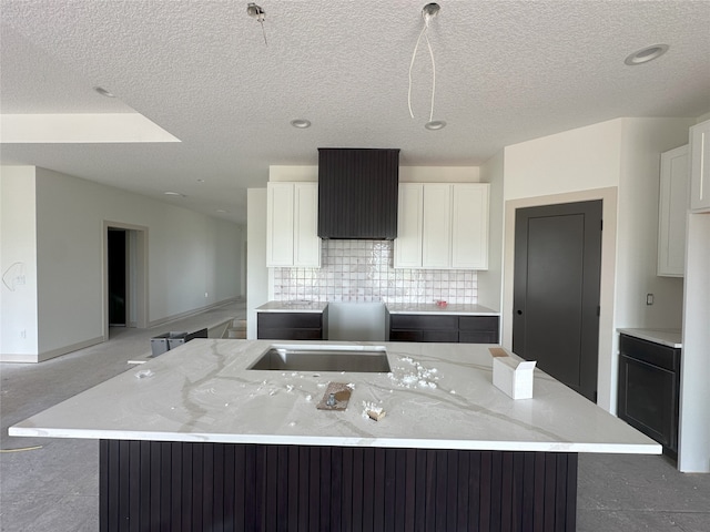 4192 NW 177th St, Clive, IA 50325 - kitchen with a large island, backsplash, white cabinets, a textured ceiling, and light stone countertops