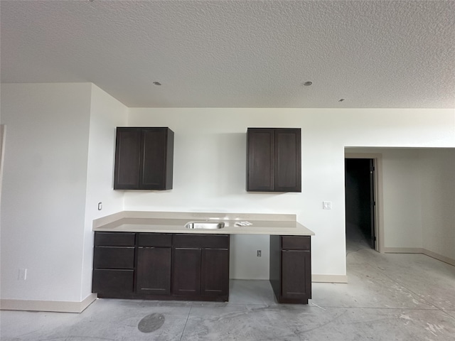 4192 NW 177th St, Clive, IA 50325 - kitchen featuring dark brown cabinets, a textured ceiling, light countertops, and concrete flooring