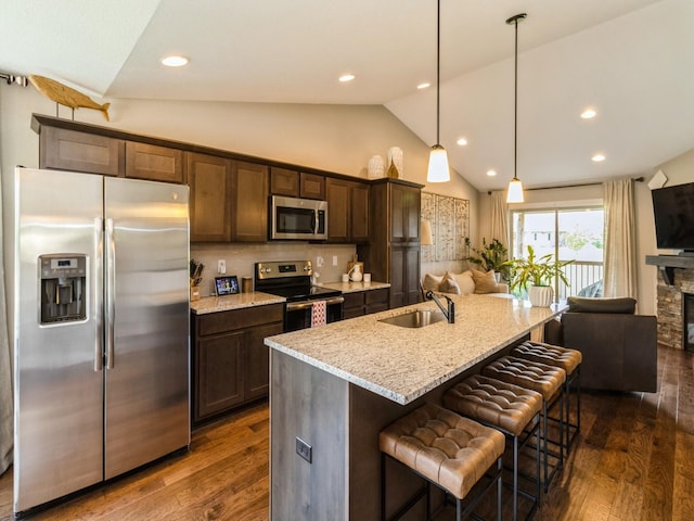 1102 NE 15th Ln, Ankeny, IA 50021 - kitchen with stainless steel appliances, dark wood-style flooring, open floor plan, light stone countertops, and dark brown cabinets